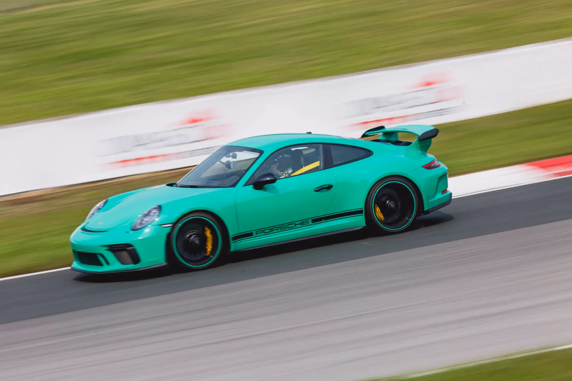 A mint green Porsche 911 GT3 cornering on track