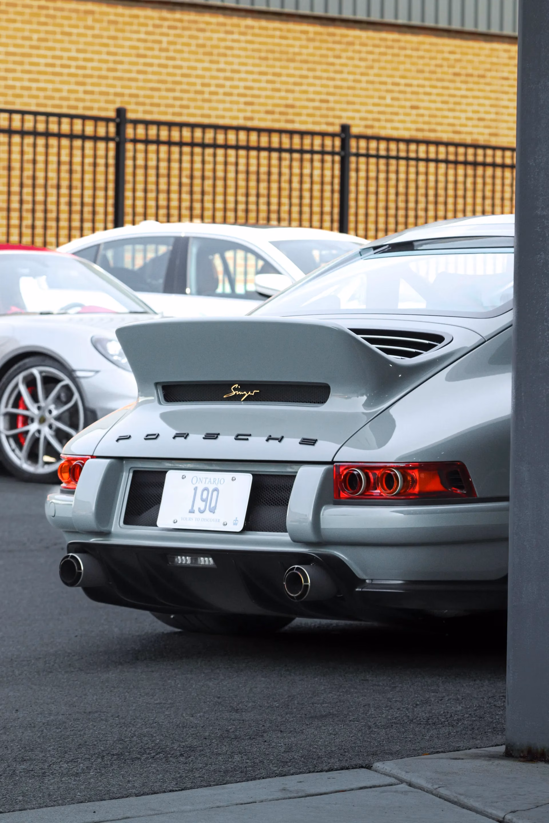 Rear of a grey restomod classic Porsche 911 with a ducktail spoiler and Ontario licence plate