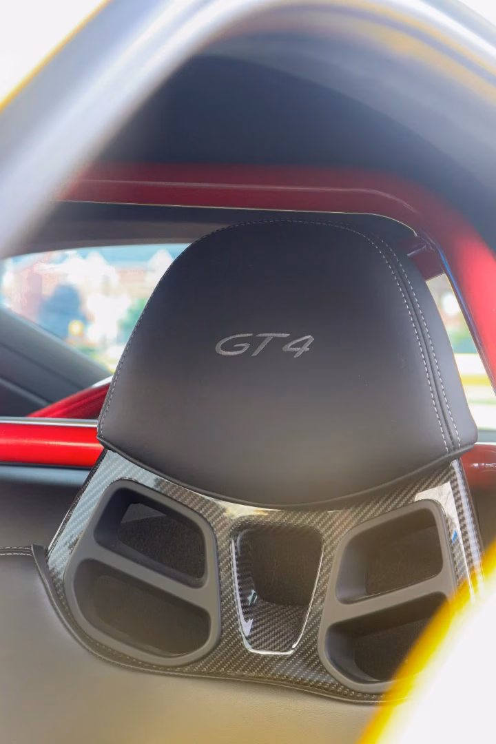 Close-up of a GT4 embroidered headrest and carbon fibre roll bar inside a Porsche