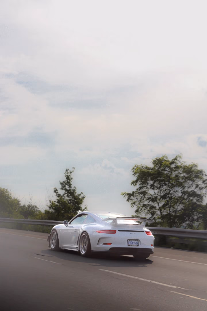A white Porsche 911 GT3 on the highway