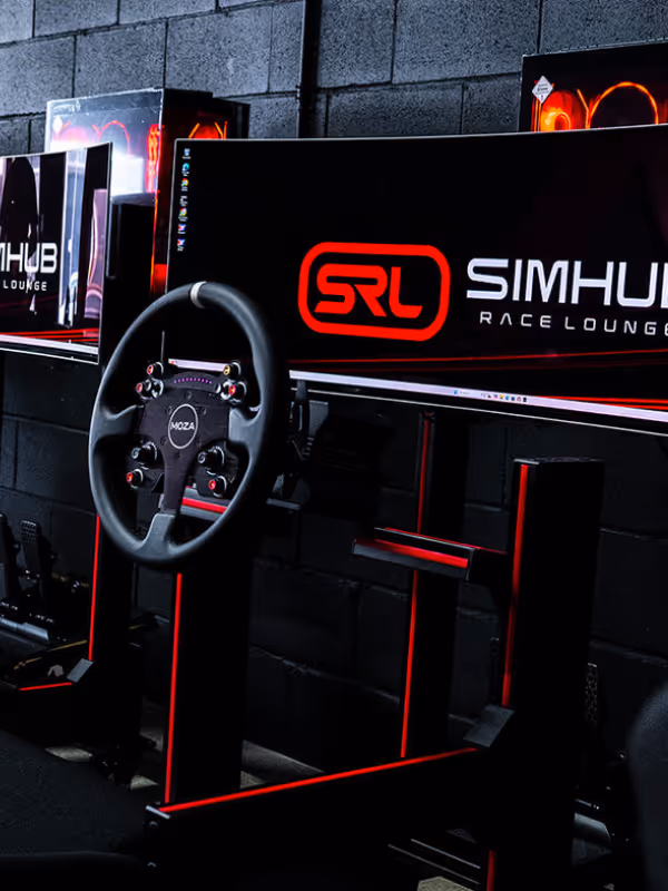 A sim racing rig with a steering wheel and screen at the SimHub Race Lounge